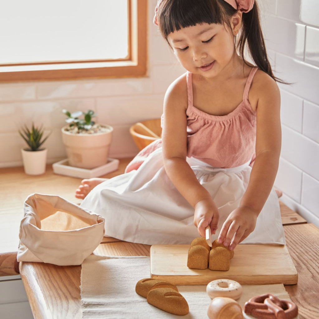 Kid playing with PlanToys Bread Set wooden toy