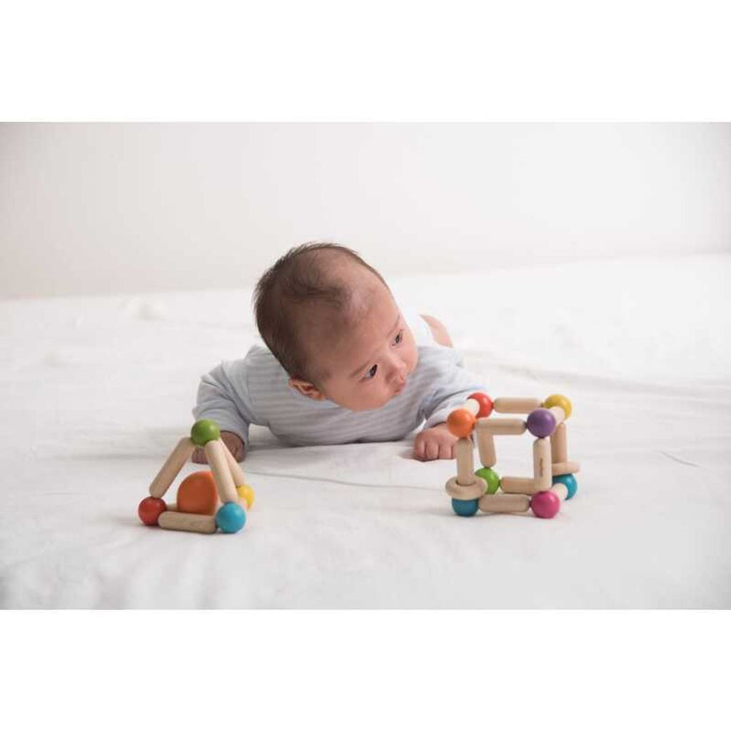 Kid playing PlanToys Triangle Clutching Toy