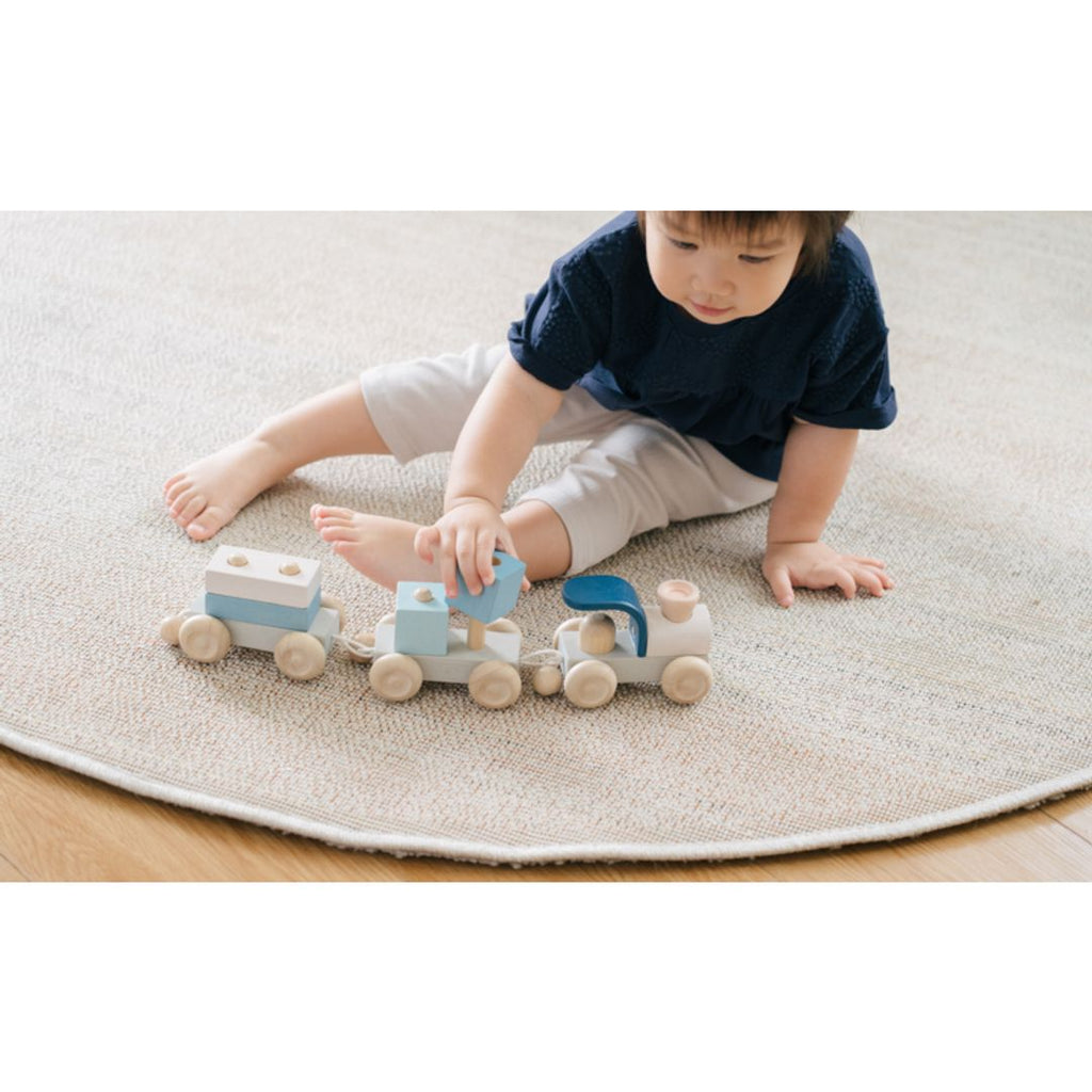 Kid playing PlanToys Stacking Train Trio - Orchard