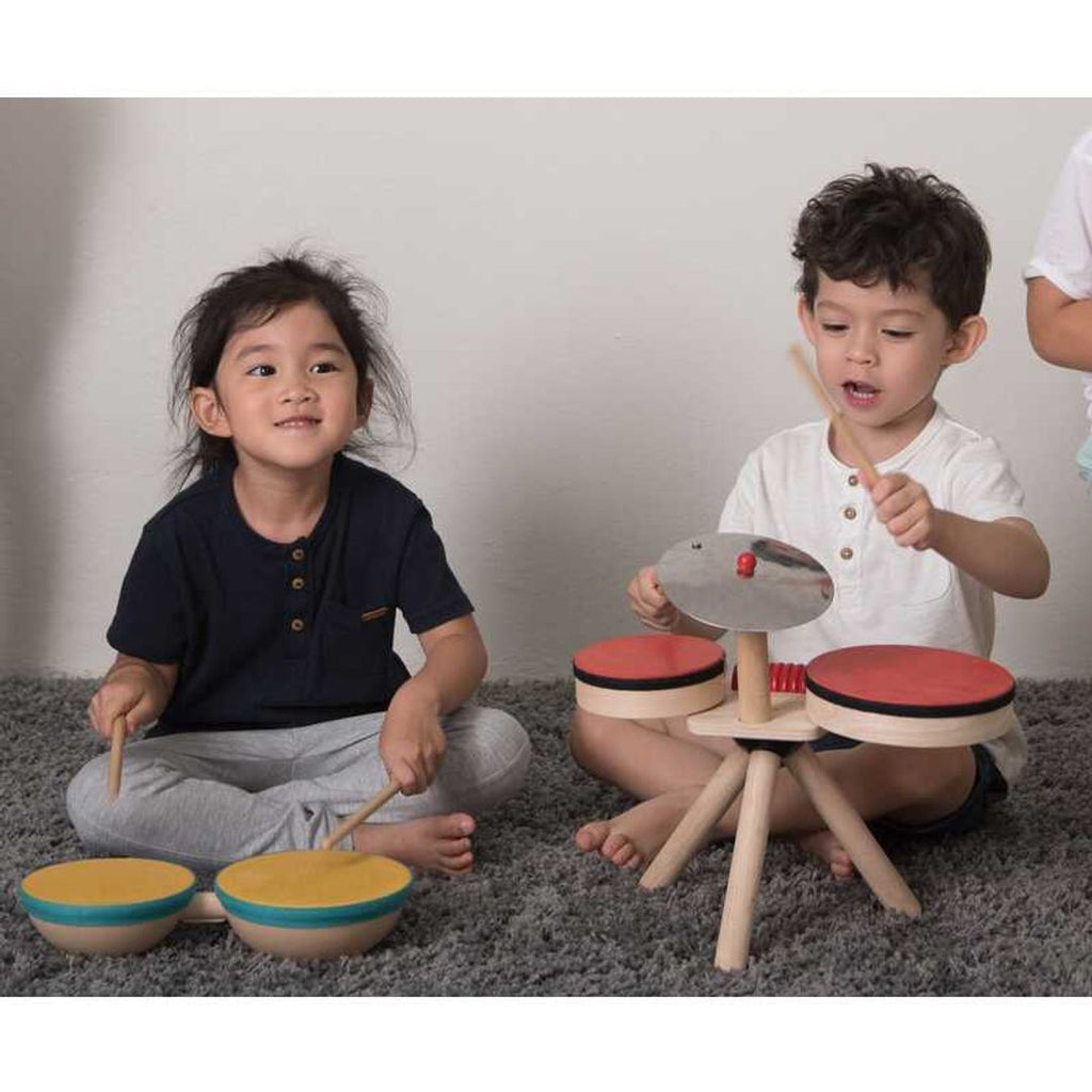 Kid playing PlanToys Double Drum